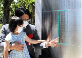慰霊碑に銘板を取り付けた遺族代表の安本篤司さん（後方）ら＝神戸市中央区楠町７、大倉山公園