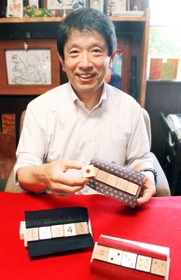 禅ダイスを手にする大西淳滋郎社長＝加古川市加古川町備後