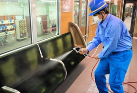 抗ウイルス液を車内にまく作業員（阪急電鉄提供）