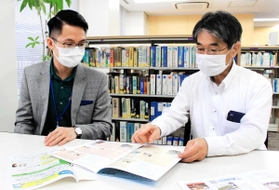 資料を見ながら対策を練る神戸国際協力交流センターのダン・チュン・フンさん（左）ら＝神戸市中央区浜辺通５