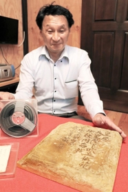 舩倉光昭さんが父の隆一さんの遺品として見つけた８ミリフィルムと竜山石＝加古川市東神吉町