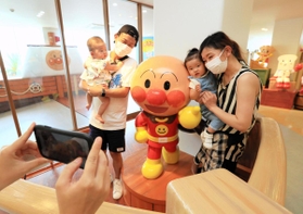 約４カ月ぶりに再開したアンパンマンと記念撮影をする親子連れ＝神戸市中央区東川崎町１（撮影・鈴木雅之）
