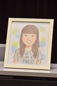 再調査委員会の報告を受けた遺族代理人の会見に置かれた女子生徒の似顔絵。１４歳の誕生日にケーキの火を吹き消す姿という