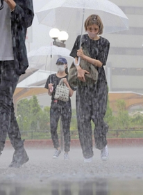大粒の激しい雨の中を歩く人たち＝３０日午前、神戸市中央区相生町３（撮影・吉田敦史）