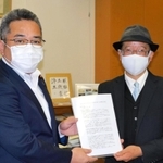 青山周平・文部科学政務官（左）に提言書を手渡す日本エンターテイメント連盟の白井博之代表理事＝文部科学省