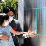 慰霊碑に銘板を取り付けた遺族代表の安本篤司さん（後方）ら＝神戸市中央区楠町７、大倉山公園