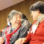 条例の改正案が可決され、支援者の角谷團さんと喜ぶ曽我部とし子さん（左）＝３月２３日、明石市議会議場