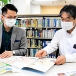 資料を見ながら対策を練る神戸国際協力交流センターのダン・チュン・フンさん（左）ら＝神戸市中央区浜辺通５