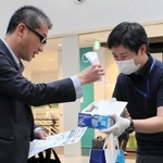 空港の利用者にマスク着用を呼び掛ける関西エアポートのスタッフ（右）＝神戸空港