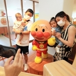 約４カ月ぶりに再開したアンパンマンと記念撮影をする親子連れ＝神戸市中央区東川崎町１（撮影・鈴木雅之）