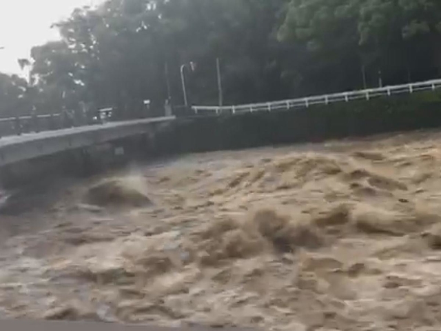 大雨で増水した川＝６日、長崎県諫早市内（提供写真）
