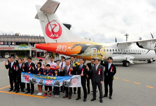 但馬空港の開港２５周年を祝い、新型機の前で記念撮影をする中貝宗治市長（前列左から３人目）や荒木一聡副知事（同７人目）ら＝２０１９年５月１８日、豊岡市岩井