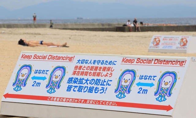 目安となる２メートル幅の看板でソーシャルディスタンスを呼び掛ける看板＝神戸市須磨区、須磨海岸（撮影・鈴木雅之）
