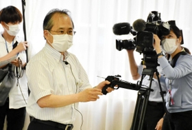 ボーガンを手に威力や種類を説明する県職員＝神戸市中央区下山手通４、ひょうご女性交流館