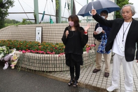 校門前に花を供え、追悼の言葉を述べる参加者＝６日午前、神戸市西区美賀多台９、神戸高塚高校（撮影・吉田敦史）