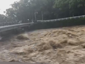 大雨で増水した川＝６日、長崎県諫早市内（提供写真）