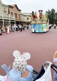 乗り物の上のミニーマウスに手を振る羽音さん（手前）＝３日、東京ディズニーランド（母親提供）