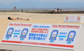 目安となる２メートル幅の看板でソーシャルディスタンスを呼び掛ける看板＝神戸市須磨区、須磨海岸（撮影・鈴木雅之）