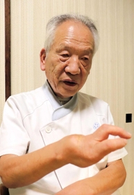 戦争で失明などの障害を負った人の苦難を語る北川忠司さん。手指をかざし、平和を願う＝神戸市垂水区
