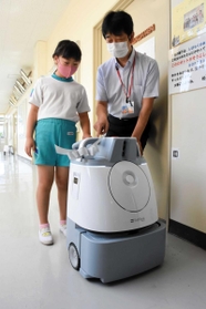 障害物を避けて廊下を掃除するロボット＝三田市志手原、志手原小学校