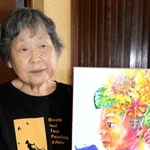 ３０年の記念誌を手に、活動を振り返る高橋智子元教諭＝神戸市西区