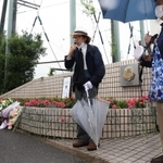 校門前に花を供え、追悼の言葉を述べる参加者＝６日午前、神戸市西区美賀多台９、神戸高塚高校（撮影・吉田敦史）