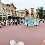 乗り物の上のミニーマウスに手を振る羽音さん（手前）＝３日、東京ディズニーランド（母親提供）