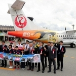 但馬空港の開港２５周年を祝い、新型機の前で記念撮影をする中貝宗治市長（前列左から３人目）や荒木一聡副知事（同７人目）ら＝２０１９年５月１８日、豊岡市岩井