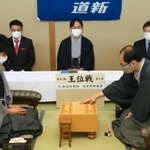 王位戦第２局で初手を指す木村一基王位（右）。左は藤井聡太七段＝１３日午前、札幌市、ホテルエミシア札幌