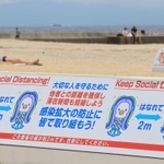 目安となる２メートル幅の看板でソーシャルディスタンスを呼び掛ける看板＝神戸市須磨区、須磨海岸（撮影・鈴木雅之）