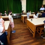 テレビを使った終業式で、校長の話を聞く神戸市立宮本小学校の児童たち＝２２日午前、神戸市中央区宮本通２（撮影・秋山亮太）