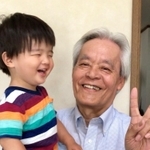 孫を抱く横野浩一さん（遺族提供）