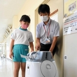 障害物を避けて廊下を掃除するロボット＝三田市志手原、志手原小学校