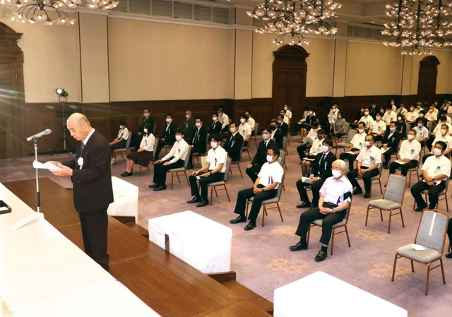 間隔を空けて座った参列者の前で、追悼の思いを述べる遺族代表の柿原啓志さん（左）＝４日午後、神戸市中央区、県公館（撮影・辰巳直之）