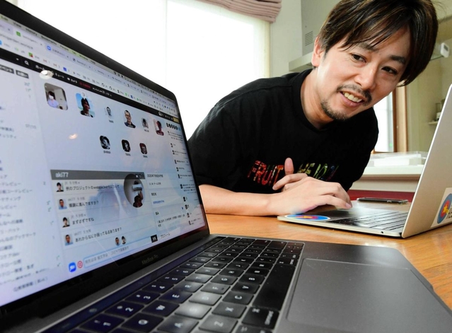 自宅の一室で、チャットで同僚らと情報交換しながらプログラミング作業を進める伊藤淳一さん＝西脇市（撮影・中西幸大）