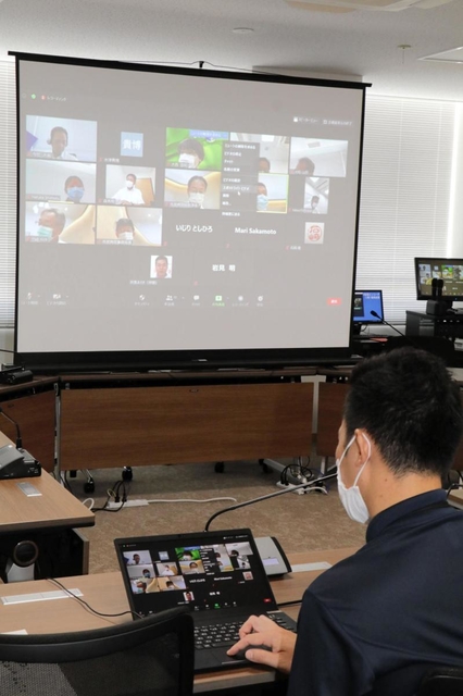 オンラインによる高砂市議会の委員会審議で、スクリーンに映し出された委員や市職員＝２１日午前、高砂市役所