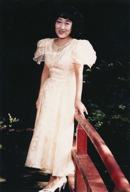 １９８０年代に自宅庭にある池の橋で写真に納まる山村美紗さん（京都新聞社提供）