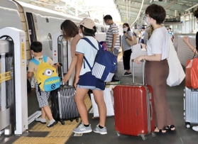 大きな荷物を持って新幹線に乗り込む家族連れら＝８日午前、ＪＲ新神戸駅（撮影・斎藤雅志）