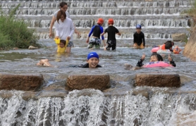 厳しい暑さの中、涼を求めて水浴びを楽しむ子どもたち＝１０日午後、神戸市東灘区の住吉川（撮影・斎藤雅志）
