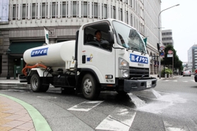 路面を冷やすため、水をまきながら走る散水車＝神戸市中央区三宮町３