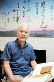 日航ジャンボ機事故への鎮魂の思いを込め、書道展を開く村尾清一さん。作業部屋には同事故で亡くなった坂本九さんの「見上げてごらん夜の星を」の歌詞を書した作品を飾る＝大阪府箕面市
