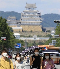 強い日差しが照りつける中、日傘を差して歩く女性ら＝１５日午後、姫路市駅前町（撮影・小林良多）