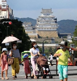 強い日差しが照りつける中、日傘を差して歩く女性ら＝１５日午後、姫路市駅前町（撮影・小林良多）