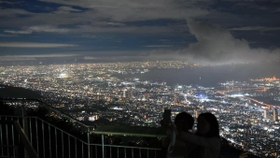 山上の涼しい風を受けながら夜景を楽しむ人たち＝２７日夜、神戸市灘区摩耶山町、掬星台