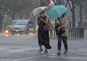 激しい雨の中を歩く人たち＝３０日午後５時４８分、神戸市中央区東川崎町１（撮影・後藤亮平）