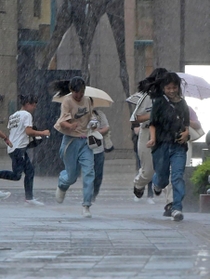 激しい雨の中を走る人たち＝３０日午後５時４１分、神戸市中央区東川崎町１（撮影・後藤亮平）