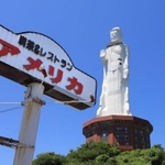 解体撤去が決まった「世界平和大観音像」の足元に並び立つ「アメリカ」の看板＝淡路市釜口