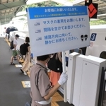 帰省客らに感染予防を呼びかける掲示板を持つ警備員＝８日午前、神戸市中央区、ＪＲ新神戸駅（撮影・斎藤雅志）