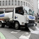 路面を冷やすため、水をまきながら走る散水車＝神戸市中央区三宮町３