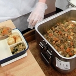 食缶に入れられ、熱々の状態で届いた「牛肉とじゃがいものみそ煮」を盛り付ける生徒＝７月１７日、神戸市垂水区神陵台３、神陵台中学校